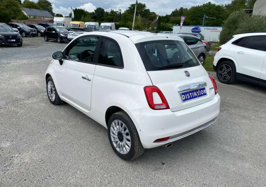 Vue 3/4 arrière droite d'une Fiat 500 blanche 2024 avec jantes alliage 16'' Spider et toit panoramique fixe.