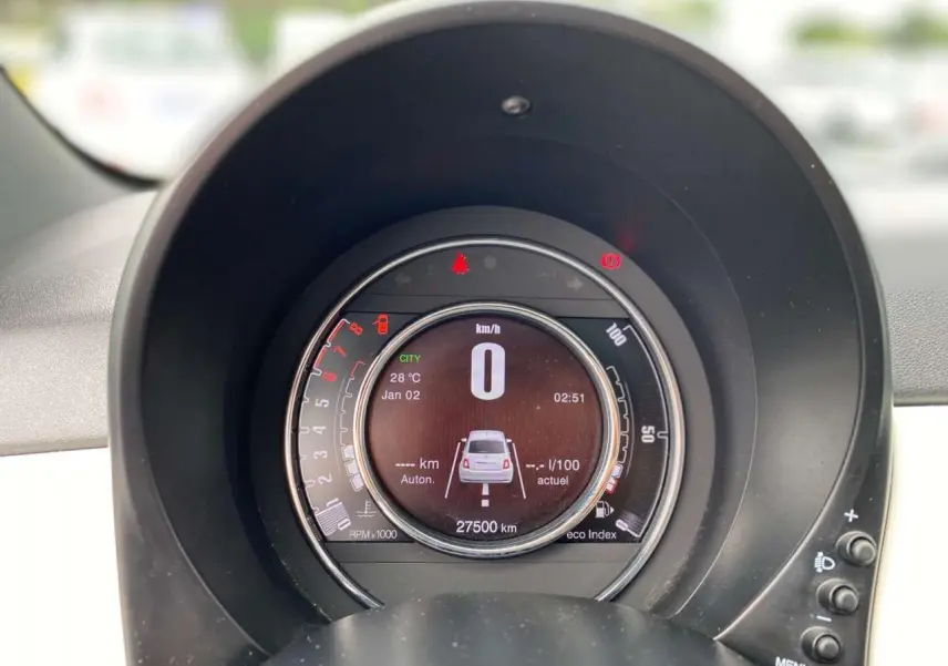 Vue rapprochée du tableau de bord numérique de la Fiat 500 blanche 2024 affichant la vitesse et l'autonomie.