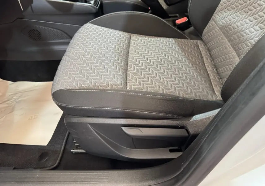 Gros plan sur le siège avant droit gris à motifs de la Renault Clio Business TCe 100 GPL blanche, intérieur côté passager.