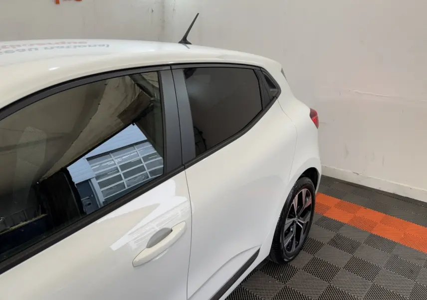 Vue 3/4 arrière côté droit d'une Renault Clio Business TCe 100 GPL blanche avec vitres teintées et jantes noires.