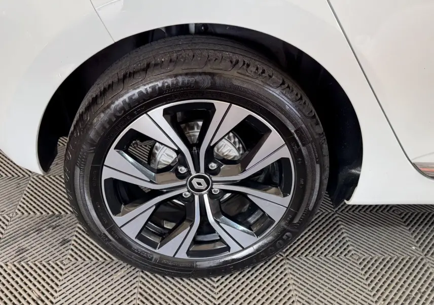 Gros plan sur la roue arrière droite blanche d’une Renault Clio 2023 avec jante alliage bicolore et logo Renault central.