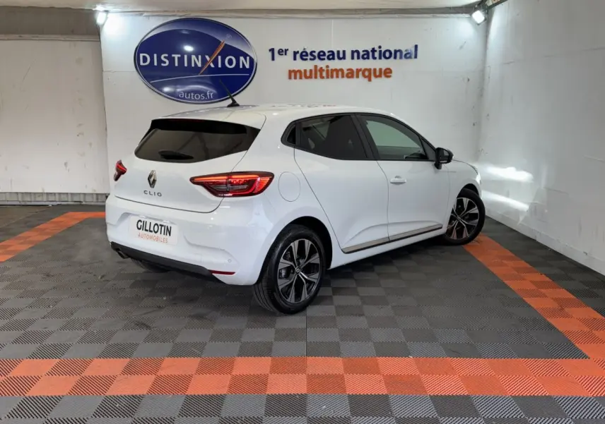 Renault Clio Business blanc vue 3/4 arrière droit, avec jantes alliage et feux arrière LED allumés.