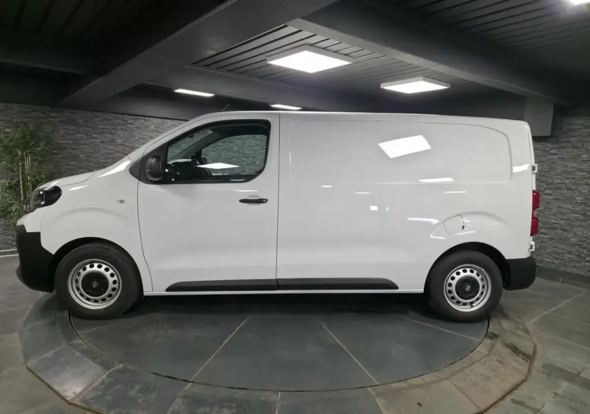 Vue de profil côté gauche d’un Opel Vivaro blanc 2025 utilitaire avec roues tôles et poignées noires.