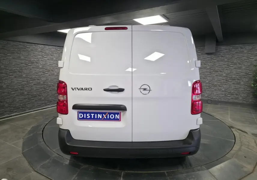 Vue arrière d’un Opel Vivaro blanc avec portes battantes et feux rouges dans un showroom intérieur.