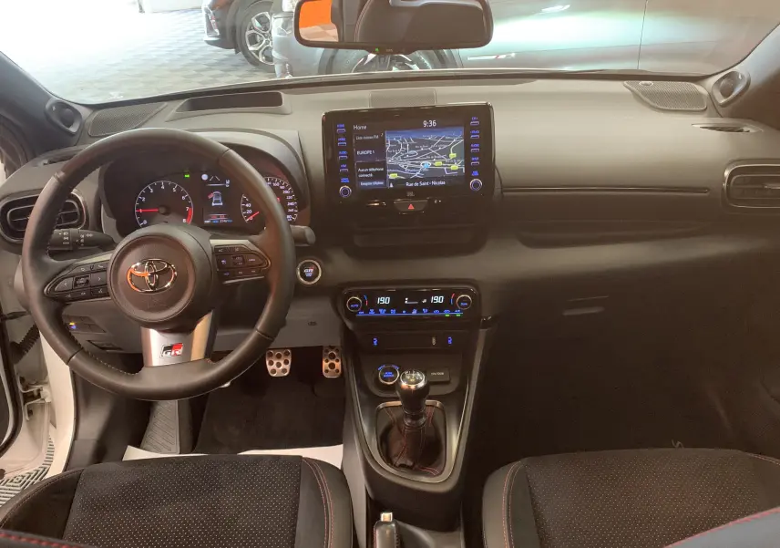 Vue intérieure de la Toyota Yaris 1.6 VVT-I 261 Premium GR 2021, tableau de bord et volant sport avec écran tactile GPS.
