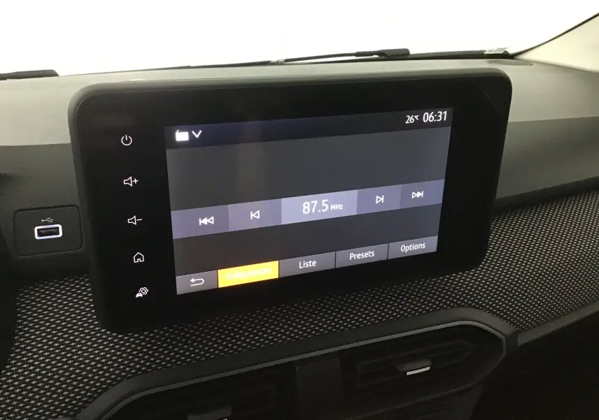 Écran tactile central affichant la radio à 87,5 MHz sur le tableau de bord du Dacia Sandero Stepway 2025 gris schiste