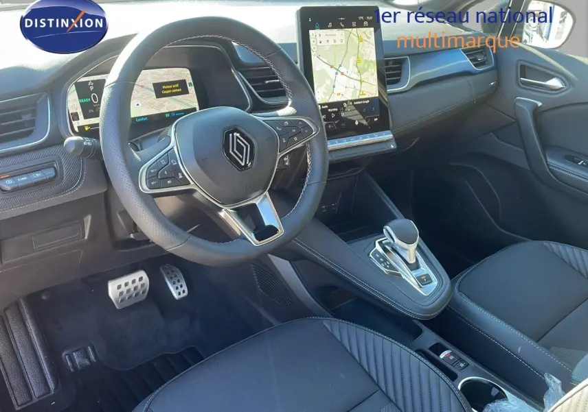 Intérieur noir du Renault Captur E-Tech 2025 vu côté conducteur, avec volant multifonction et écran tactile central.