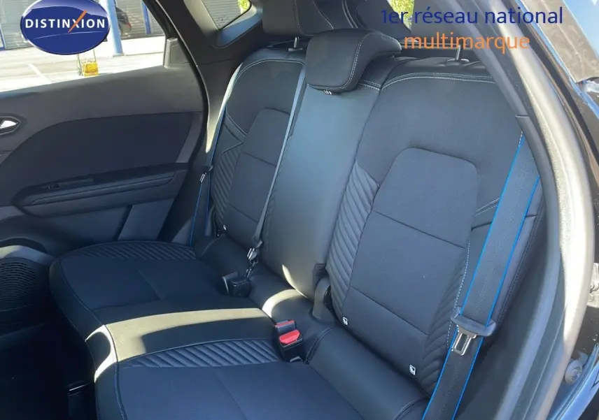 Vue intérieure côté droit des sièges arrière noirs du Renault Captur E-Tech hybride 2025 avec surpiqûres bleues et ceintures assorties.
