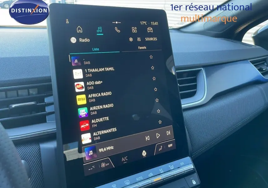 Vue rapprochée de l'écran tactile central du tableau de bord du Renault Captur noir étoile métal 2025, affichant les stations radio numériques.