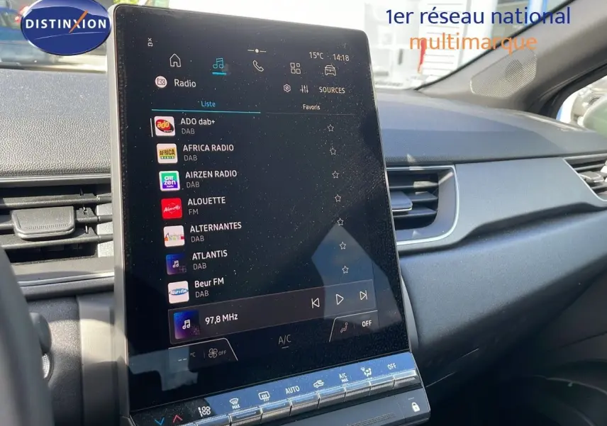 Vue intérieure du tableau de bord du Renault Captur E-Tech Hybrid 2025, avec grand écran tactile central affichant les stations radio.