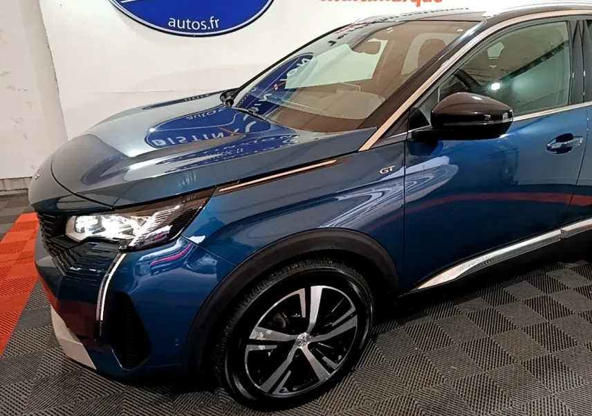 Vue 3/4 avant droit d’un Peugeot 3008 GT bleu avec phares LED et jantes alliage distinctives.