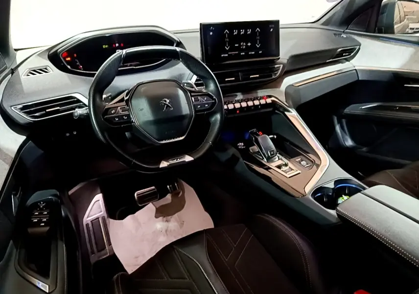Vue intérieure côté conducteur du Peugeot 3008 GT 2021, volant cuir multifonctions et écran tactile central lumineux.