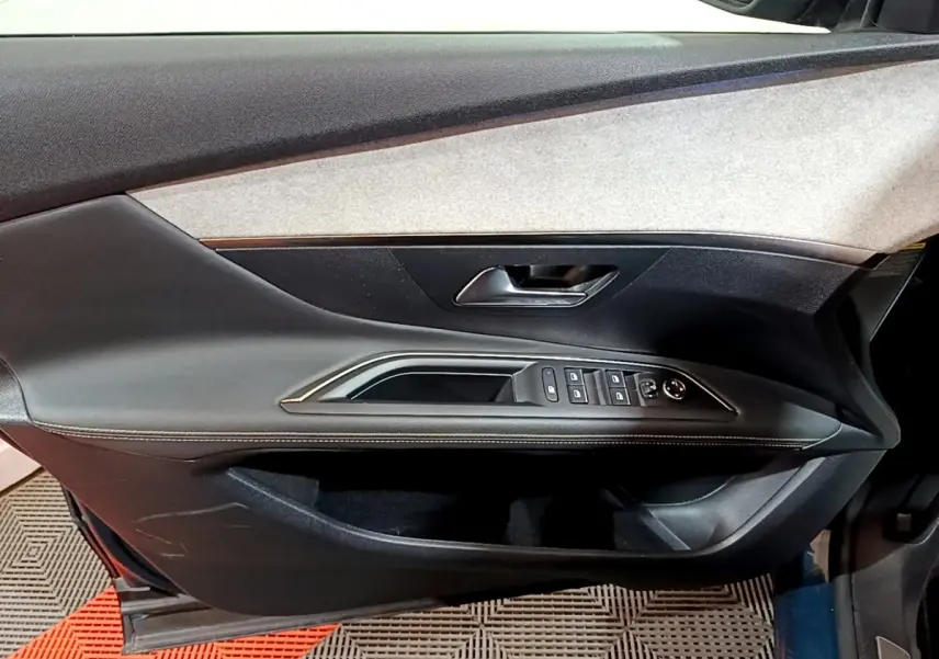 Vue intérieure de la porte côté conducteur du Peugeot 3008 bleu, avec commandes des vitres et poignée intégrée.