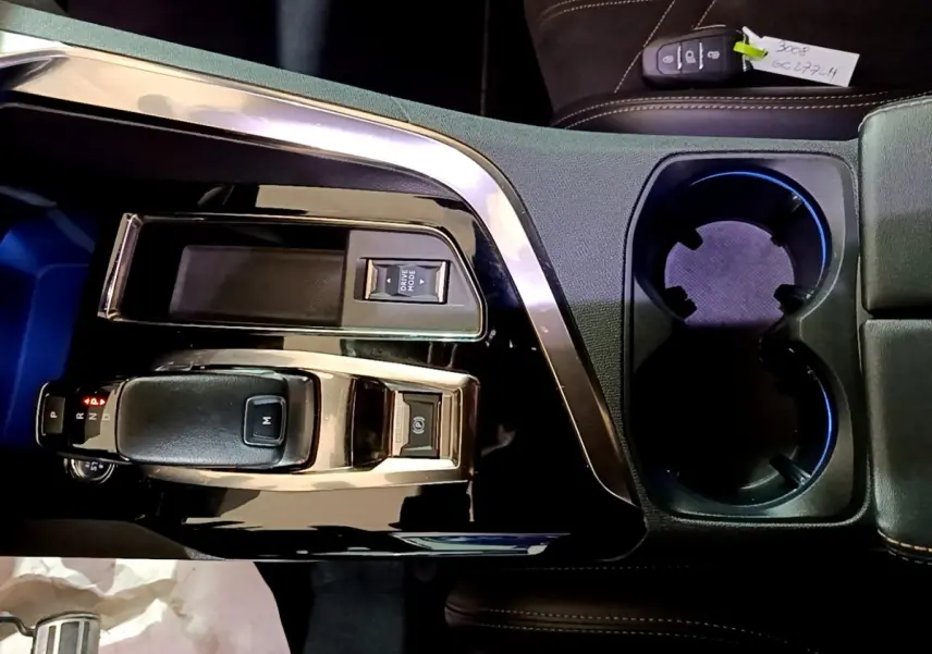 Vue plongeante sur la console centrale noire du Peugeot 3008 GT 2021 avec levier de vitesse et porte-gobelets.