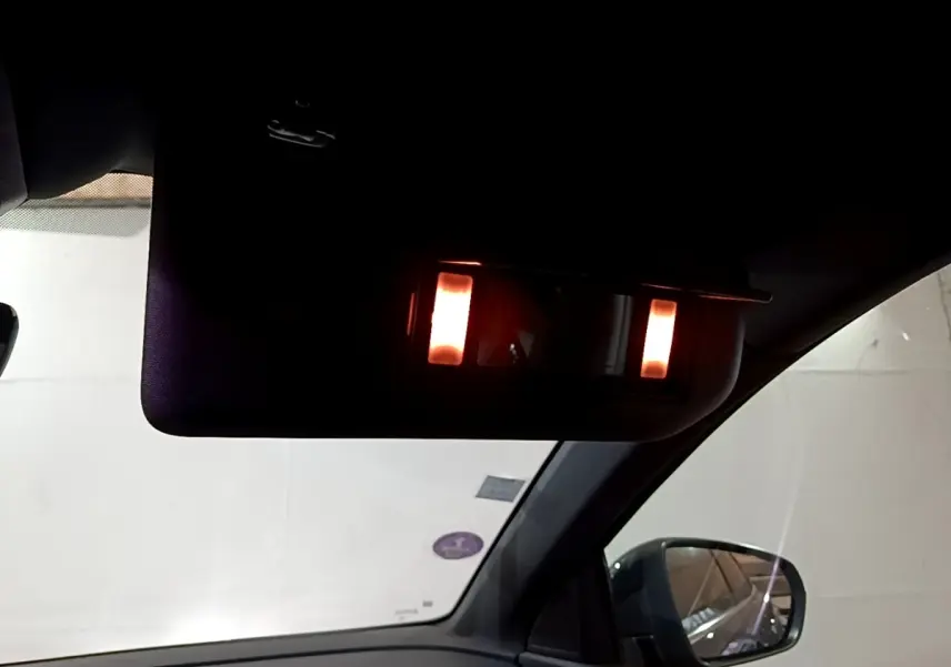 Vue intérieure côté droit du Peugeot 3008 bleu 2021, miroir de courtoisie avec éclairage allumé sur pare-soleil.