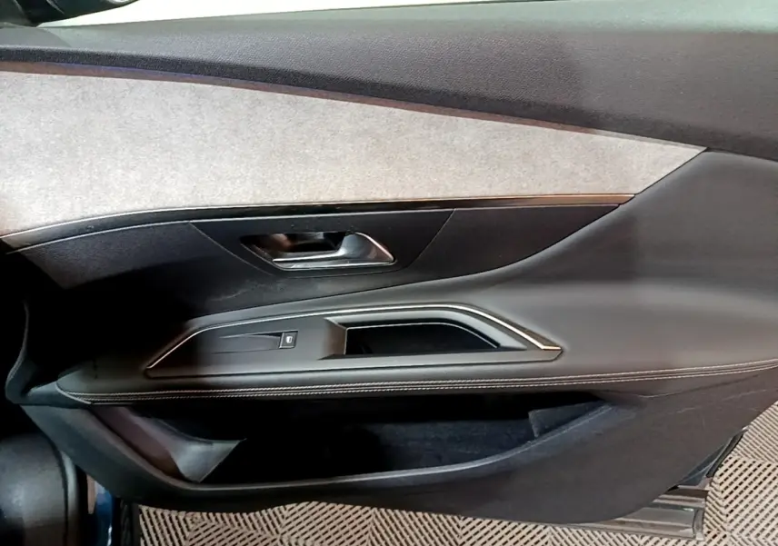 Vue rapprochée de la porte avant gauche du Peugeot 3008 bleu, avec garniture noire et insert gris clair.