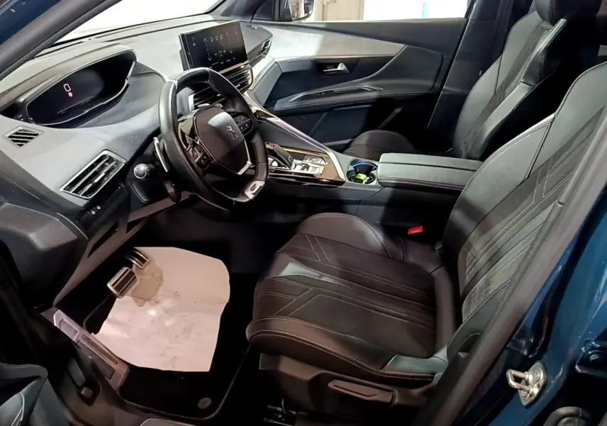 Vue intérieure côté conducteur du Peugeot 3008 bleu 2021, volant cuir multifonctions et écran tactile central visible.