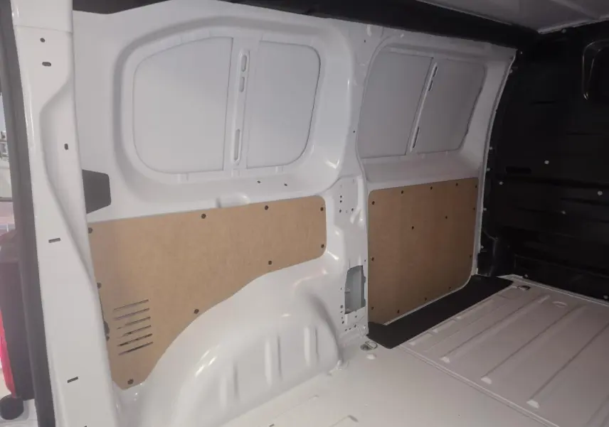Intérieur du coffre blanc de l’Opel Vivaro 2025, vue latérale droite avec panneaux de protection en bois clair.