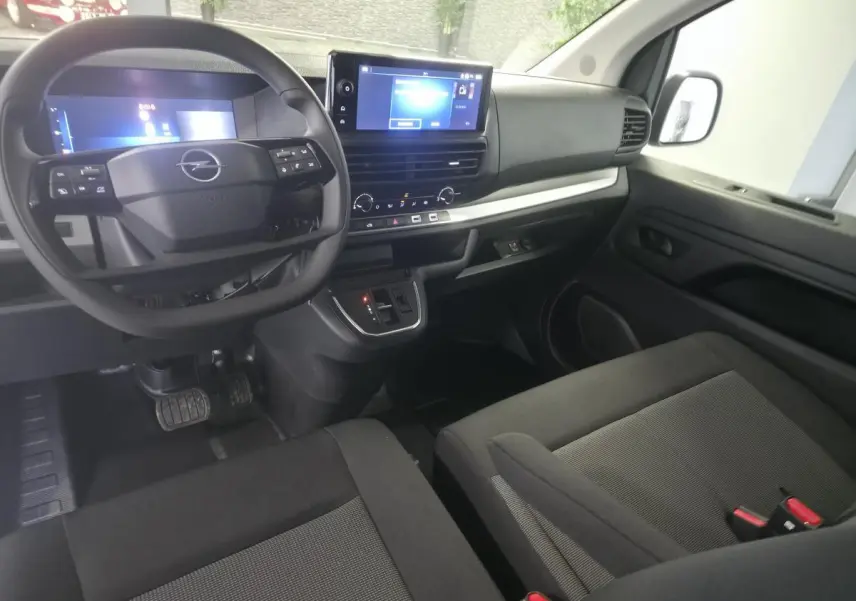 Vue intérieure côté conducteur de l'Opel Vivaro 2025 avec tableau de bord noir, écran tactile 10'' et volant multifonction.