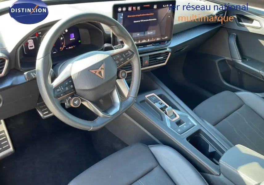 Vue intérieure côté conducteur du CUPRA Leon 2025, volant cuir multifonction et écran tactile central moderne.