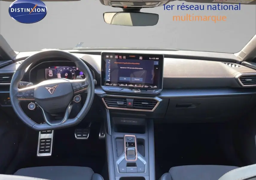 Vue intérieure frontale du tableau de bord et volant cuir noir de la CUPRA Leon 1.5 eTSI 2025 avec écran tactile central.
