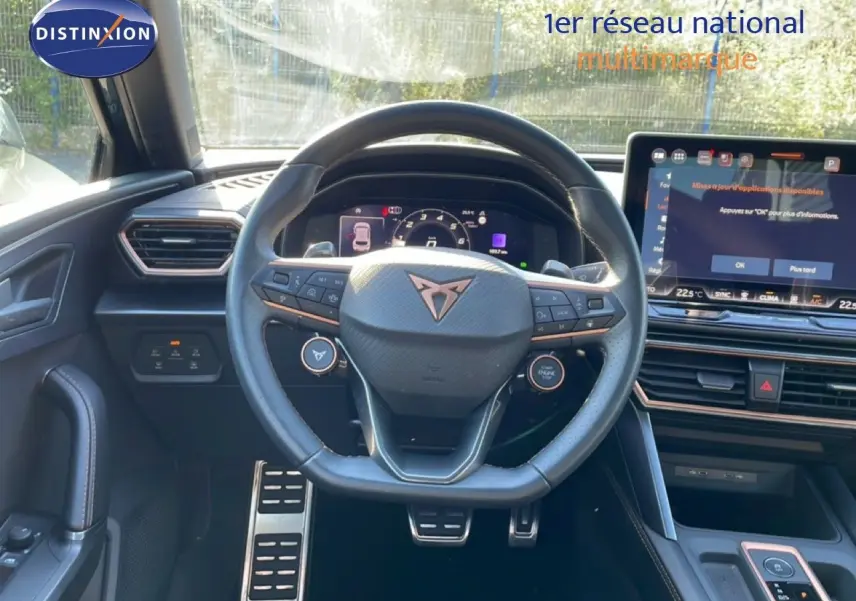 Vue intérieure centrée sur le volant cuir noir de la CUPRA Leon 2025 avec tableau de bord numérique et écran tactile.