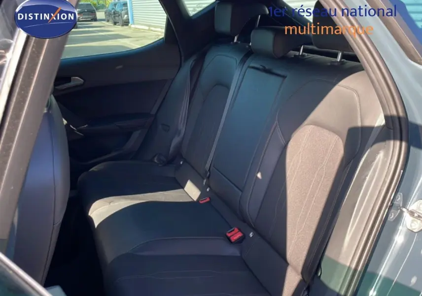 Vue intérieure sur les sièges arrière en tissu noir de la CUPRA Leon 1.5 eTSI 150CH DSG, porte arrière ouverte côté droit.