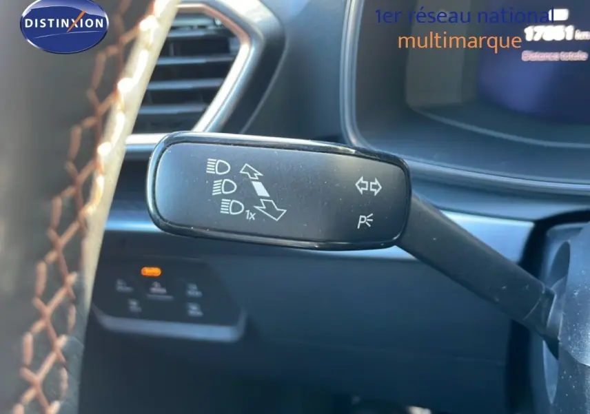 Gros plan sur la manette de clignotant à gauche du volant d’une CUPRA Leon 1.5 eTSI 150CH DSG 2025, intérieur noir.
