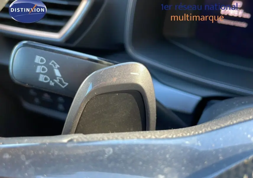 Gros plan sur la palette de changement de vitesse côté droit du volant d'une CUPRA Leon bleu Fjord, intérieur moderne.