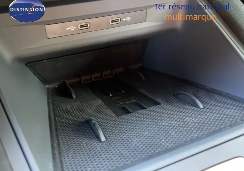 Gros plan sur la console centrale d’une CUPRA Leon 2025, montrant les ports USB et un espace de rangement noir.