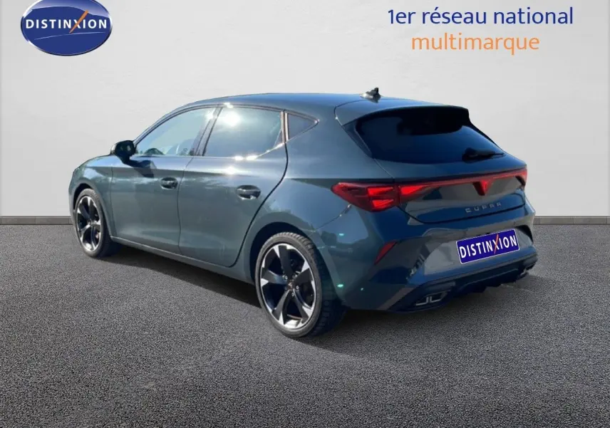 Vue 3/4 arrière droite d'une CUPRA Leon 2025 bleu Fjord avec jantes noires et feux arrière LED allumés.