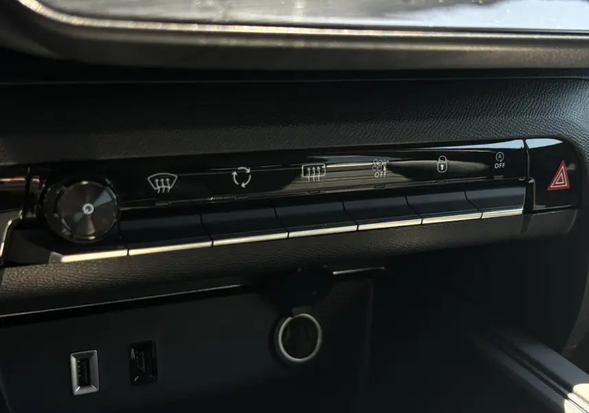 Détail du tableau de bord noir du Citroën C5 Aircross Hybrid 2025 montrant les commandes de climatisation et deux ports USB.
