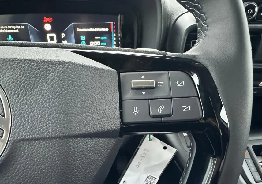 Gros plan sur le volant noir du Citroën Berlingo 2025, montrant les commandes audio et téléphone intégrées.