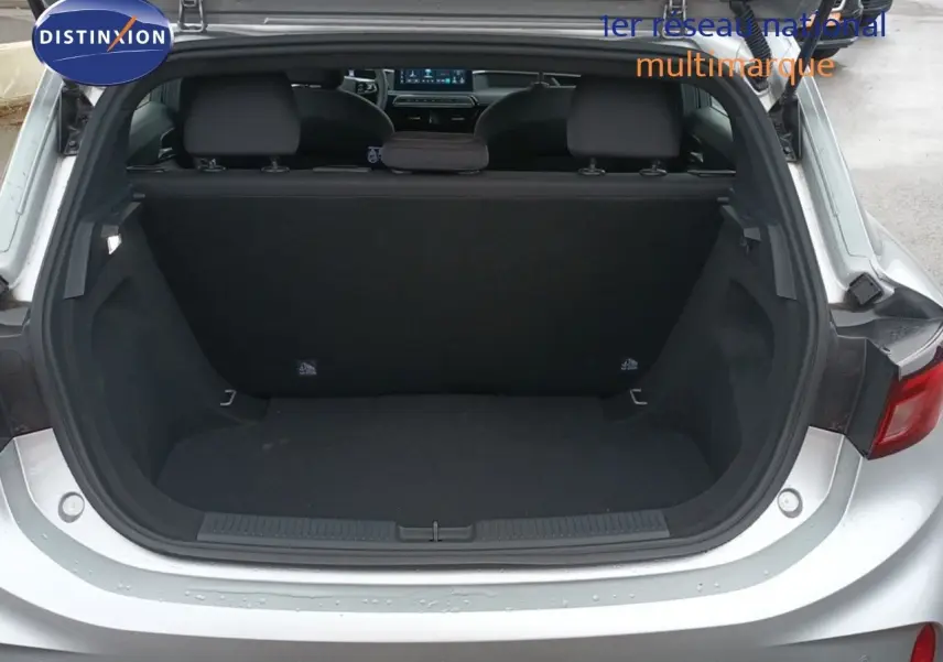 Coffre ouvert d'une MG3 Hybrid+ gris 2024, vue arrière montrant l'espace de chargement et la banquette rabattable.