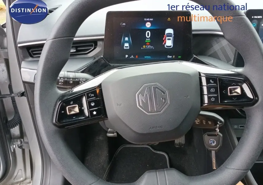 Vue rapprochée du volant MG d’une MG3 gris 2024 avec tableau de bord numérique et clé insérée.