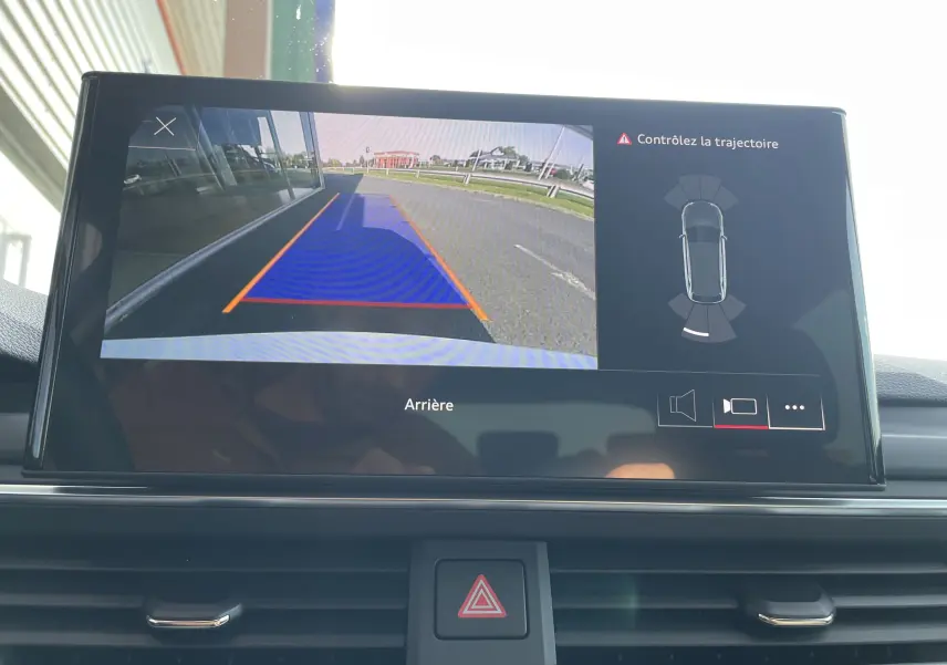 Écran multimédia montrant la caméra de recul avec trajectoire assistée d'une Audi A4 Avant blanche, vue arrière.