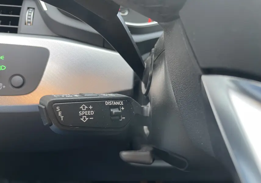 Le levier de régulateur de vitesse de l'Audi A4 Avant 40 TDI 2022, vue rapprochée côté gauche du volant.