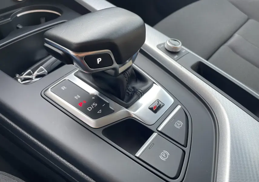 Gros plan sur la console centrale de l'Audi A4 Avant 40 TDI 204 Quattro 2022, avec levier de vitesse automatique et logo S4.