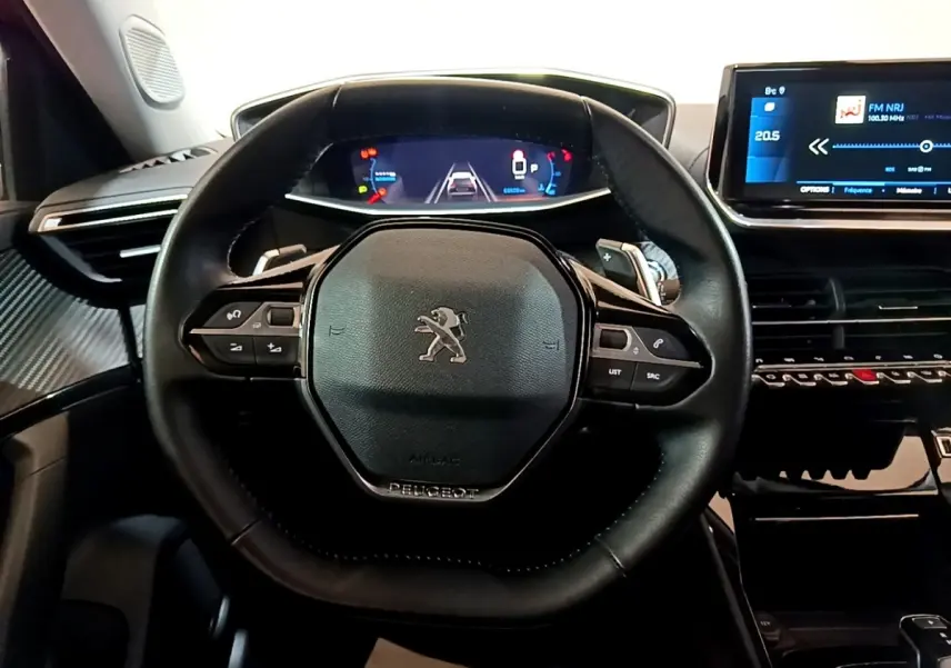 Vue centrée sur le volant cuir noir du Peugeot 2008 2021, avec tableau de bord numérique et écran tactile visible.