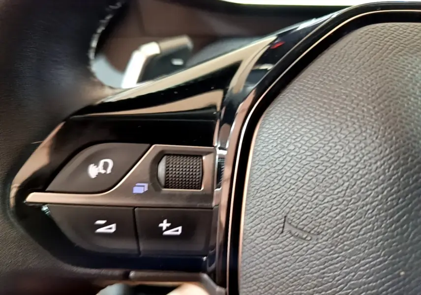 Gros plan sur les commandes vocales et volume au volant cuir du Peugeot 2008 PureTech 130 2021.