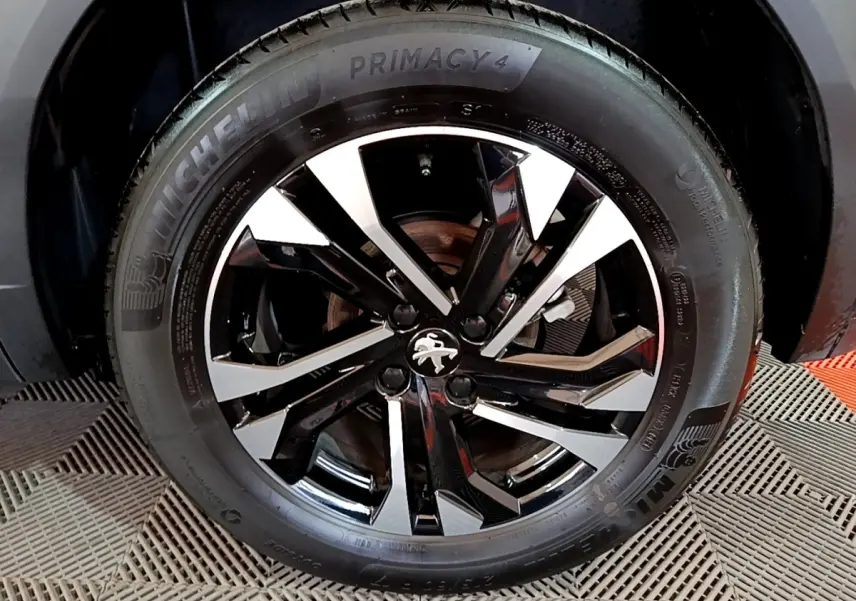 Gros plan sur la roue avant droite du Peugeot 2008 2021 avec jante alliage noire et argent et pneu Michelin Primacy 4.