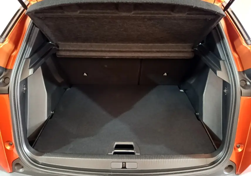 Coffre ouvert vu de l'arrière d'un Peugeot 2008 orange, montrant un espace de chargement propre et spacieux.