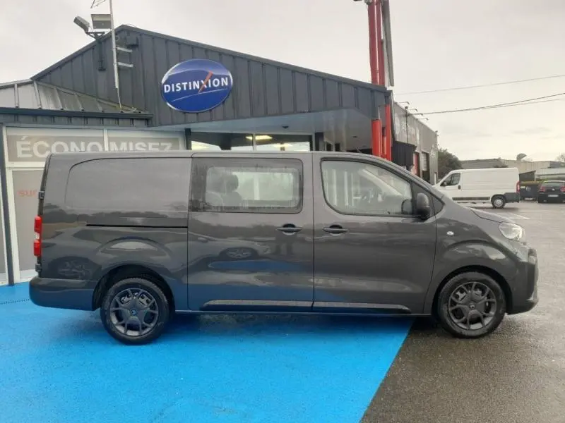 Vue de profil droit du Citroën Jumpy gris Titane métal avec porte latérale coulissante, roues foncées et vitres teintées.