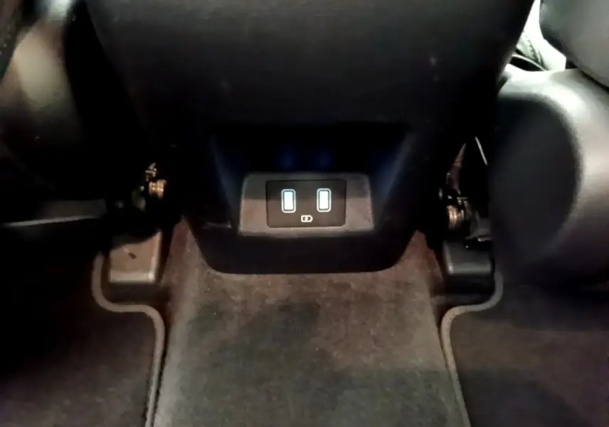 Vue rapprochée des prises USB arrière sous les sièges noirs du Hyundai Tucson bleu 2023 hybride rechargeable.