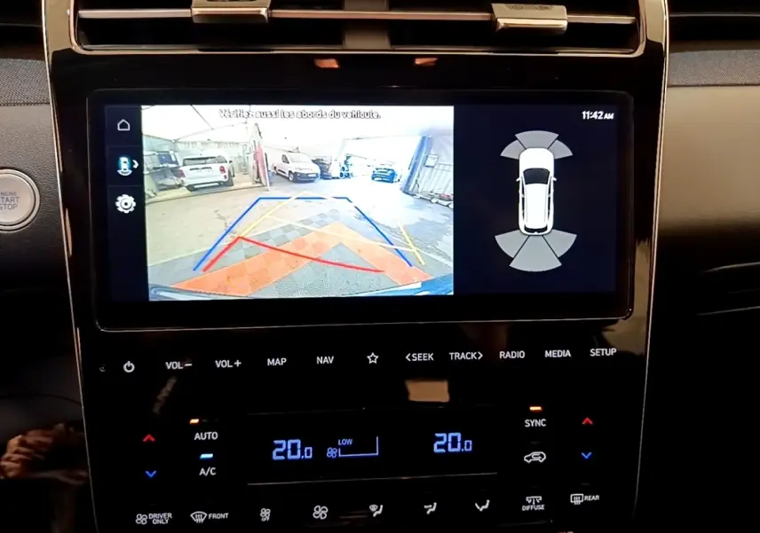 Écran tactile central affichant la caméra de recul et les capteurs de stationnement du Hyundai Tucson bleu 2023.