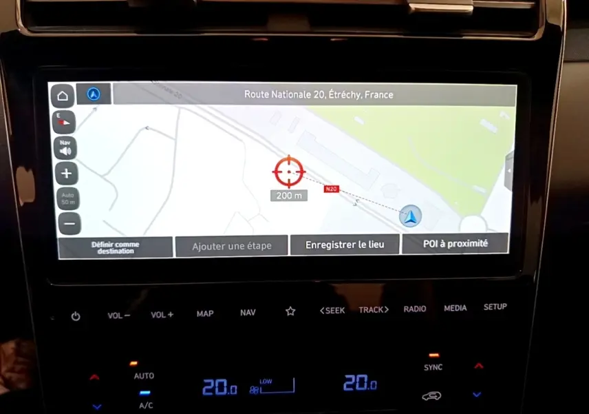 Écran tactile central du Hyundai Tucson bleu 2023 montrant la navigation GPS et commandes climatisation digitales.