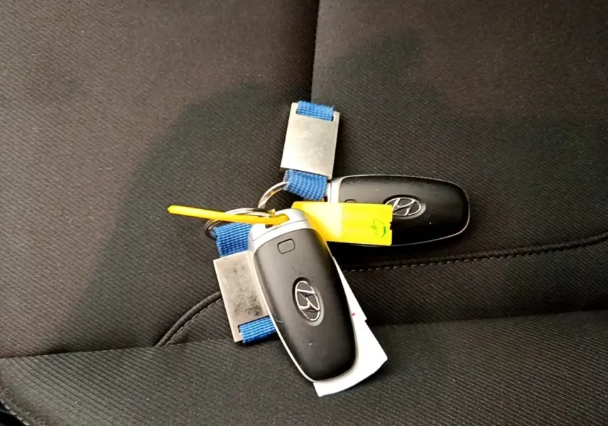 Gros plan sur deux clés Hyundai noires posées sur un siège en tissu noir à l'intérieur du véhicule.