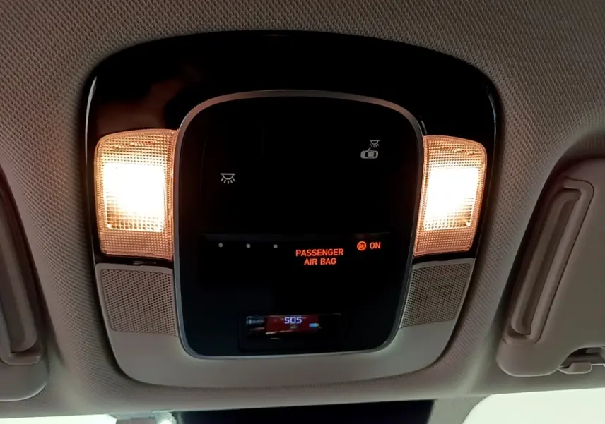 Plafonnier intérieur avec éclairage allumé et affichage de l'airbag passager activé dans un Hyundai Tucson bleu 2023.