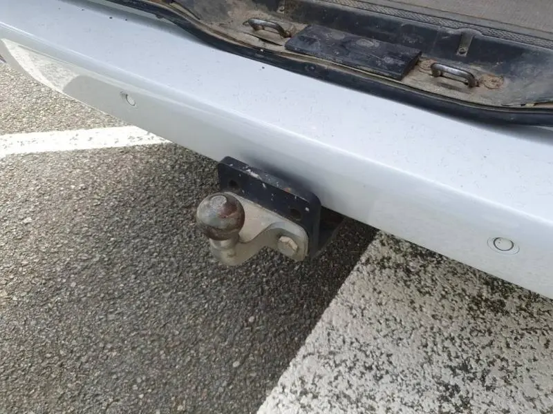 Gros plan sur l'attelage d'un Mercedes Vito Fourgon blanc pur spéciale, vu à l'arrière sur un sol bitumé.