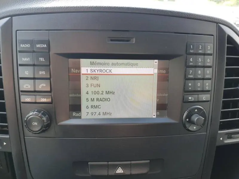 Écran multifonction du tableau de bord du Mercedes Vito Fourgon blanc, affichant la liste des stations radio.